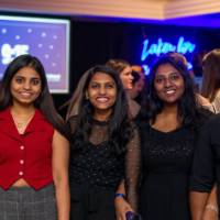 A group of grads smile and pose for a photo at Toast